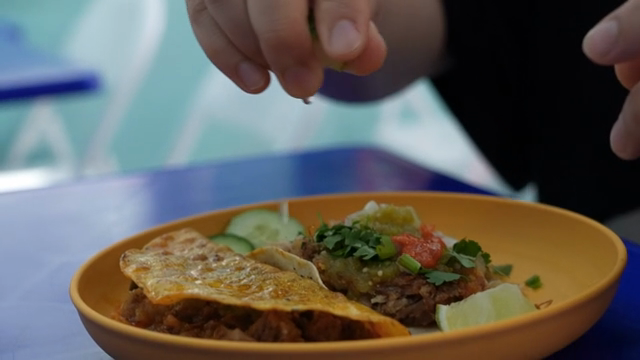 Squeezing lime over a taco on a plate