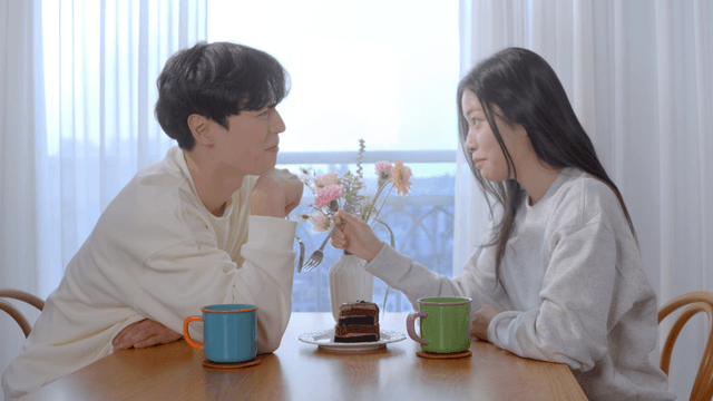 Couple enjoying cake by bright window