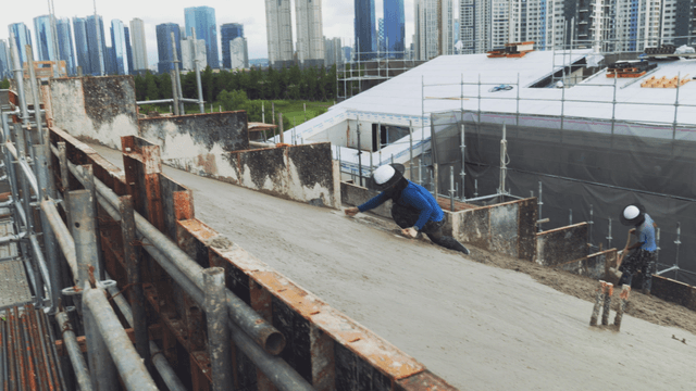 workers smoothing concrete on a slope