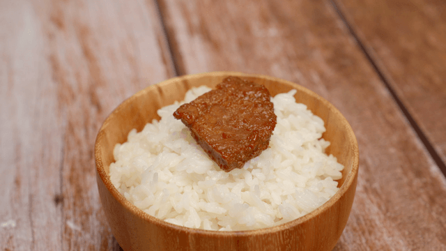Bowl of rice with a piece of marinated meat