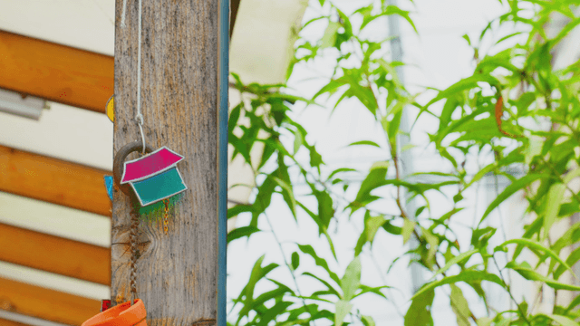 Wood pillar with house-shaped decor under sunlight