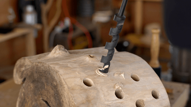 Woodcraft artisan drilling multiple holes in a wooden barrel