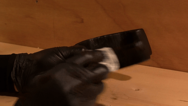 Woodcraft artisan polishing a wooden sculpture with cloth