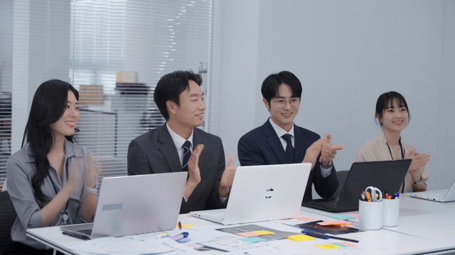 Colleagues in a meeting room clapping