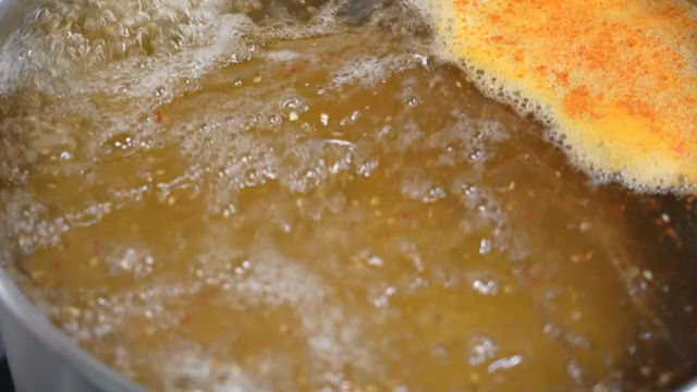A pot of soup boiling with spices