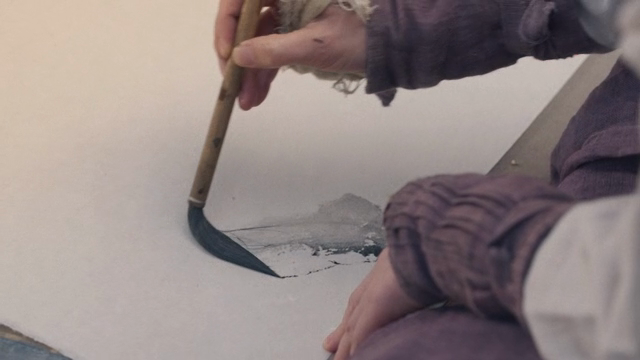 A person painting with a traditional brush