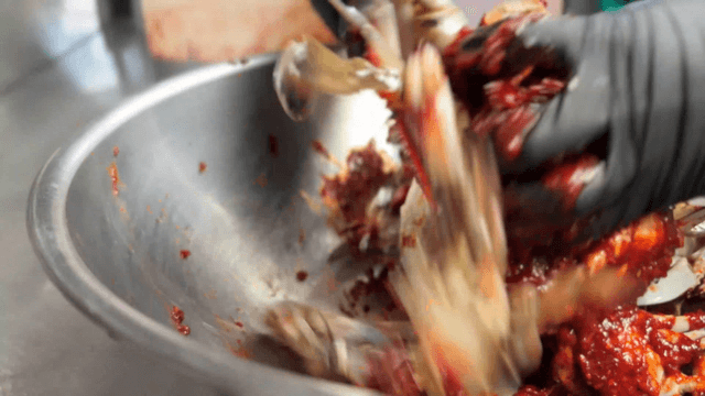 Marinated crab mixed in a metal bowl