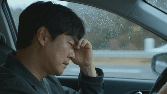 Driving of a tired man on a rainy day