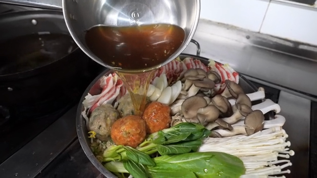 Broth being poured over a hot pot