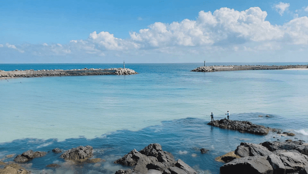 Clear seashore with people fishing