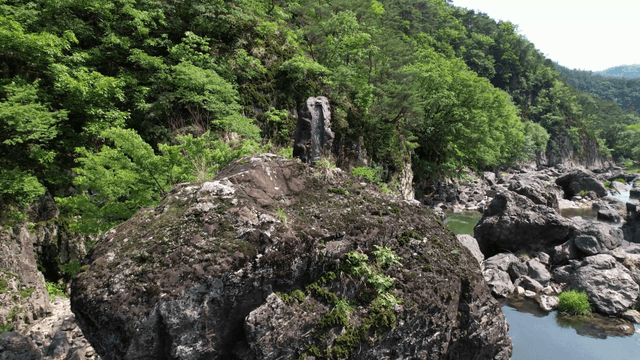 계곡과 푸른 숲으로 둘러싸인 바위