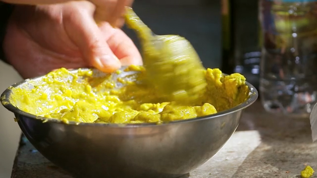 Mixing guacamole in a metal bowl