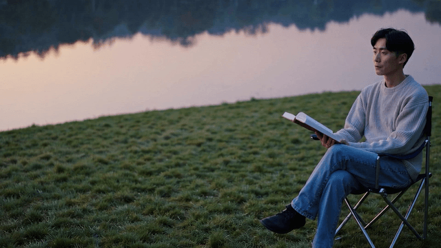 A man gazing into the distance by a tranquil lakeside