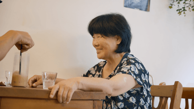 An elderly woman having a conversation at a cafe