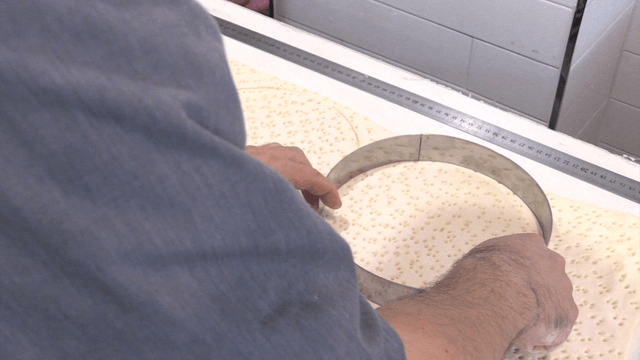 반죽을 원형틀로 잘라내는 제빵사