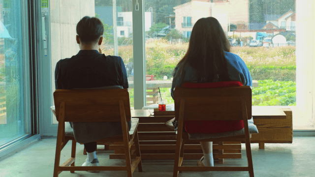 Two people sitting in a cafe enjoying a view