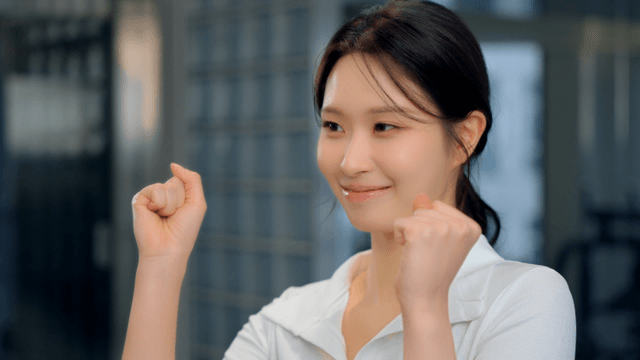 Smiling young woman cheering with a raised fist