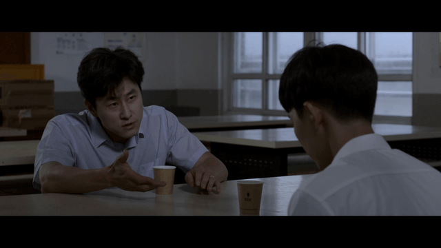 Student and teacher talking seriously while drinking beverage
