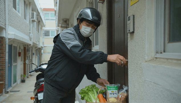 Delivery man leaving groceries at a door