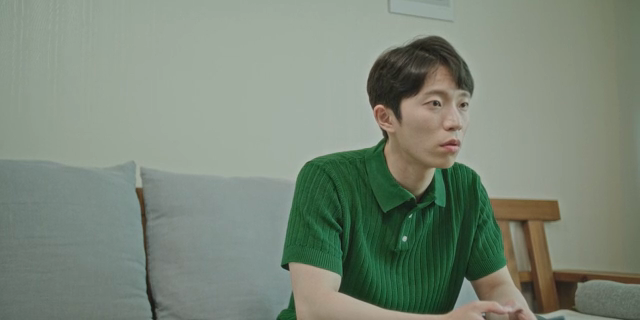 소파에 앉아 누군가와 대화하는 남자