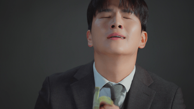 Man in a suit smelling a stack of money