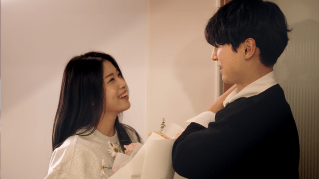 Newlywed couple exchanging flowers at the doorway