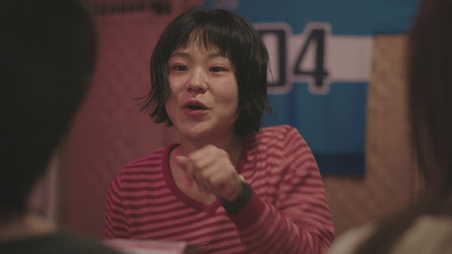 Woman in a striped shirt talking indoors