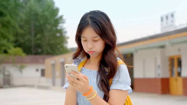 기차역에서 핸드폰을 확인하는 여성