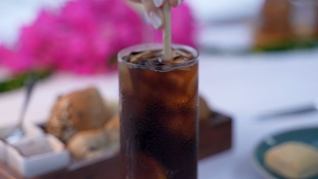 A refreshing iced coffee being stirred