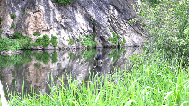 Wide river with a person fishing in the middle