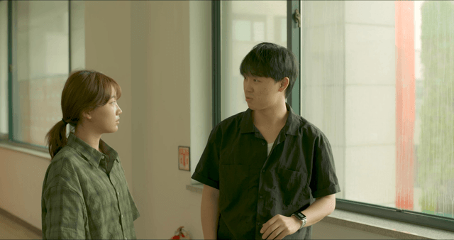 Two people talking in a hallway