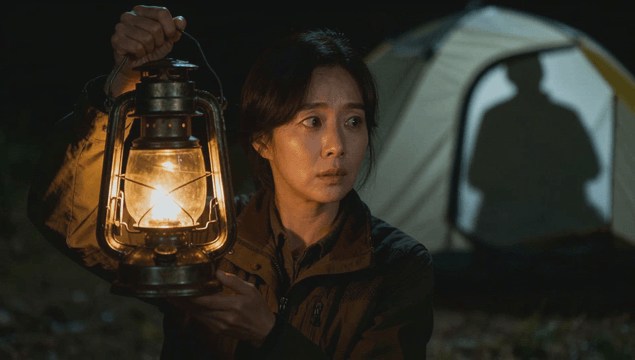 Silhouette searching with lantern beside tent shadows