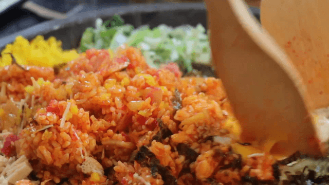 Korean fried rice being mixed in a stone plate