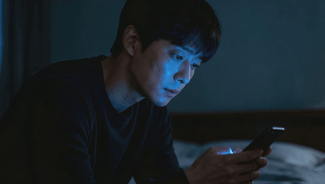 Man using smartphone in a dimly lit room