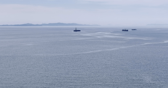 Calm sea with distant ships and islands
