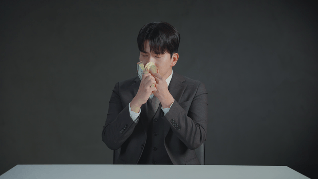 Man smelling money with a satisfied expression