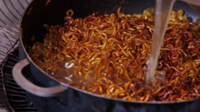 Pouring broth over noodles