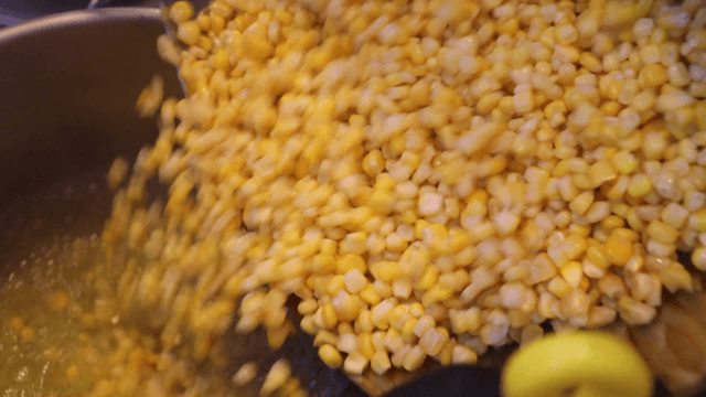 Corn being poured into a boiling pot