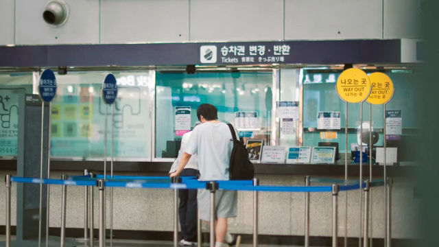 People at a ticket counter in a station