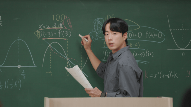 Teacher explaining math on a chalkboard