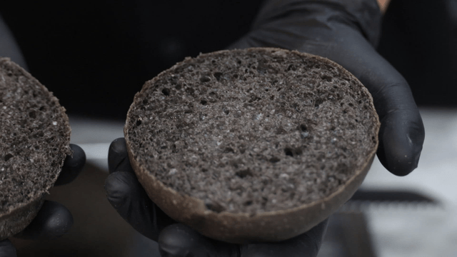 장갑을 낀 손에 들린 검은 버거 번