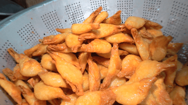 쟁반에 쌓이는 황금색 튀김 만두들
