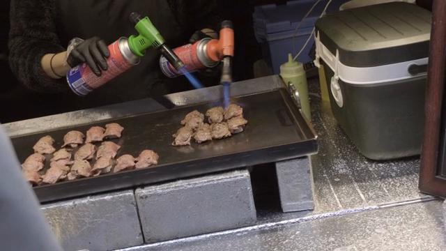 그릴 위에서 토치로 구워지는 소고기