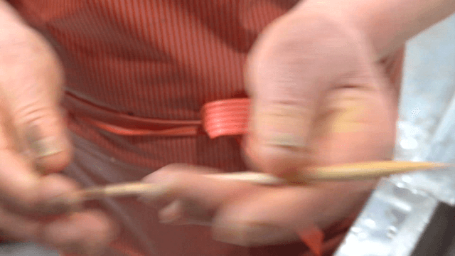 Person inspecting long chopsticks in kitchen