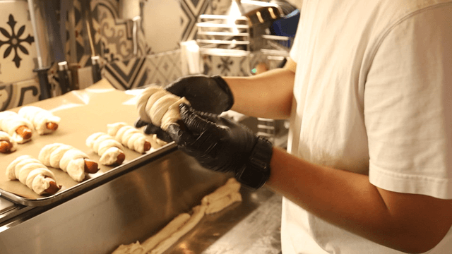 Baker making sausage bread