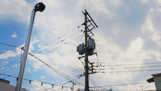 Electric pole and wires against a cloudy sky