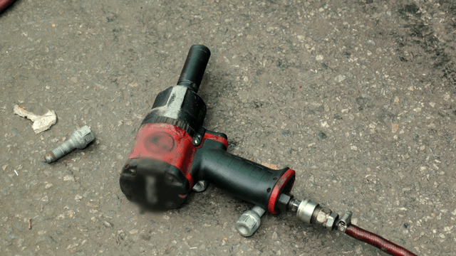 Air impact wrench on asphalt ground