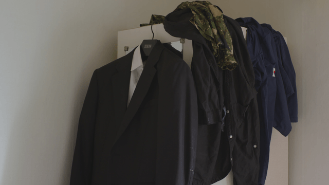 Various clothes hanging on a wardrobe