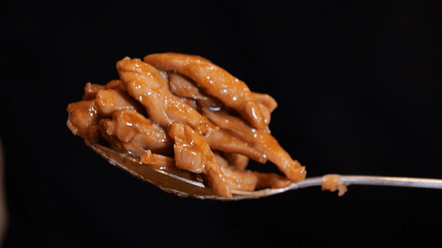 Spoonful of glazed chicken pieces