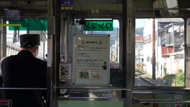 A locomotive driver driving through a quiet Japanese village